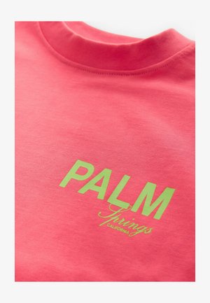 Felpa di cotone rosa con scollo rotondo e testo stampato verde "PALM Springs CALIFORNIA." Texture liscia e design casual.