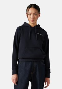 Marineblaue Kapuzenjacke aus weichem Stoff, mit einer Fronttasche, Kordeln am Hals und einem kleinen gestickten Logo auf der Brust.