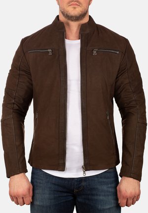 Giacca in pelle marrone con colletto alto, due tasche sul petto con zip e due tasche laterali. Superficie testurizzata con cuciture dettagliate.