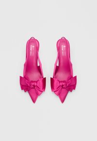 Różowe szpilki na paseczku z odkrytą piętą, z ostrymi noskami i dużymi kokardami z przodu. Gładka faktura i wegańskie materiały.