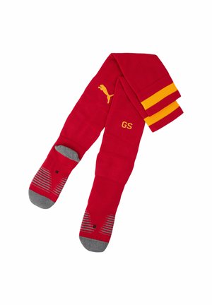 Rote Sportsocken mit gelben Streifen nahe am oberen Rand, graue Zehen und Fersen, Puma-Logo auf der Wade und die Initialen "GS" auf einer Socke eingestickt.