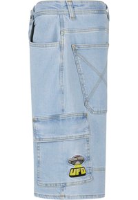 Jeanshorts i lyseblå med cargo-design, som har flere lommer og et UFO-logo merket. Laget av bomull med gule sømmer.