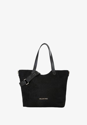 Sac cabas noir en tissu texturé, avec des poignées en cuir et une bandoulière amovible ornée d'un logo embossé. Accent doré à l'avant.
