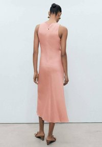 Abito midi senza maniche in morbido tessuto pesca, con texture liscia, corpino aderente, gonna svasata e zip sul retro. Design semplice ed elegante silhouette.