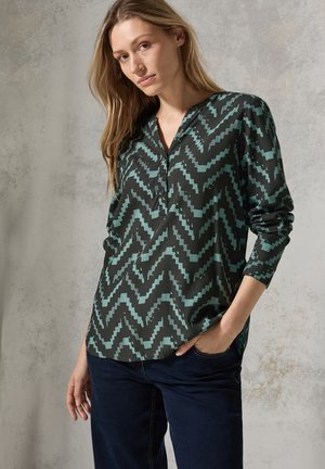 Blusa negra con patrón de zigzag turquesa, de manga larga y escote en V. Tejido suave con un ligero brillo, que presenta una abertura con tres botones.