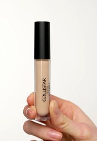 Corrector Collistar en un tubo transparente con tapa negra; tono beige claro y cremoso; textura suave; etiquetado como "LIFT HD+".