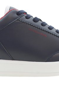 Navy Leder Sneaker mit roten Akzenten und weißer Sohle. Zeigt "U.S. POLO ASSN" in Rot an der Seite, mit runden Schnürsenkeln und nahtlosem Design.