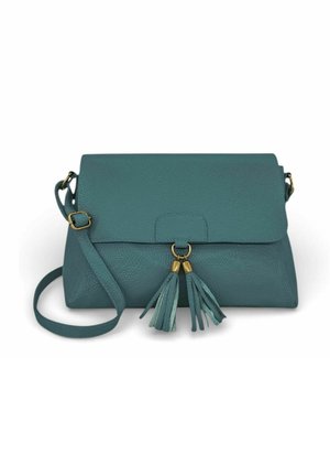 Sac bandoulière en cuir bleu sarcelle avec une sangle ajustable et deux décorations à pompons suspendues à un anneau doré sur le rabat avant.