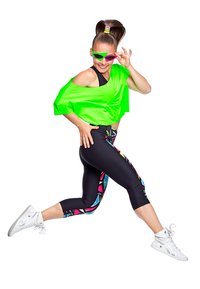 Neon zelena oversized majica, crne tajice s šarenim geometrijskim uzorcima, bijele tenisice i živopisne sunčane naočale.