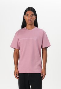 Roze katoenen t-shirt met korte mouwen, ronde halslijn en een horizontale lijn grafiek boven een circulair logo op de borst.