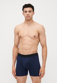 Navyblaue Boxershorts mit einem schwarzen elastischen Bund, der den Text "ONLY & SONS" trägt. Das Material wirkt glatt und hat ein enges Design.