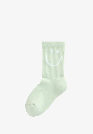 Calza a coste verde chiaro con un design di faccina sorridente bianca sulla parte superiore. Texture morbida con un'altezza standard alla caviglia.