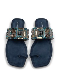 Sandalias de ante azul marino con tiras contrastantes y adornadas con gemas multicolores y acentos metálicos. Diseño de suela plana.