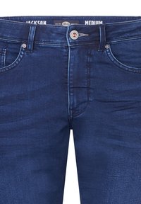 Jeans in denim blu scuro con lavaggio medio, dotati di cinque tasche, hardware argentato e una patch con logo sulla vita.