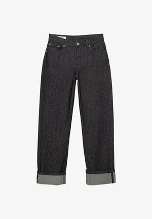 Fekete farmernadrág laza szabással, rollott szegéllyel és kontrasztos belső cuff-fal. Fém gomb és szegecsek mint fémes részletek.