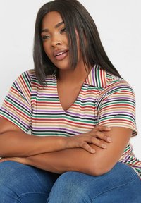 Flerfärgad randig T-shirt med V-ringning och korta ärmar. Färgerna inkluderar orange, lila, grön och krämfärgad. Mjukt tyg med en avslappnad passform.