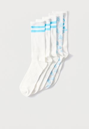 Cinque calzini da ginnastica bianchi con strisce blu su tre paia e motivi floreali blu su due paia, disposti sovrapposti su uno sfondo bianco.