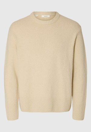 Cream-colored sweater made of textured fabric. Features a ribbed round neckline and ribbed cuffs, with a relaxed fit and long sleeves.