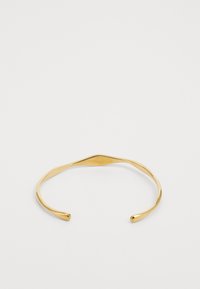 Brazalete de metal dorado con un diseño curvado y suave. Presenta extremos abiertos y una sutil ondulación en la banda, proporcionando una apariencia elegante.