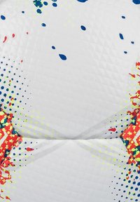 Pallone da calcio con una superficie bianca texturizzata e motivi di spruzzi colorati in rosso, blu e giallo fluorescente. Pannelli esagonali e pentagonali.