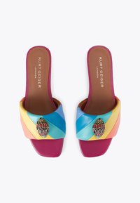 Sandali scivolati con una tomaia in pelle multicolore caratterizzata da strisce diagonali, un'importante decorazione di gioielli e un tacco a blocco viola.