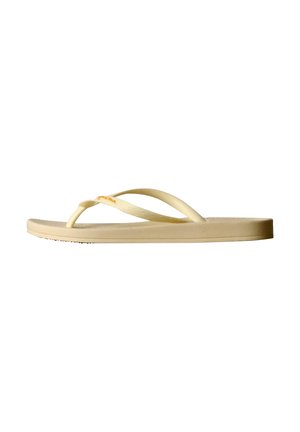 Sandale tongs en caoutchouc beige avec une bride simple et une légère décoloration sur le dessus de la bride.