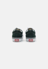 Rohe suede tossud valgete aktsentidega, lame kummist tallaga, tagumise logo ja kontrastset õmblustetailiga kanna ja ülaservade juures.