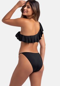 Črni enokrilni bikini z nabrano podrobnostjo ob vrhu. Gladek material, prilagojen kroj in minimalističen dizajn. Visoko pasovne hlačke.