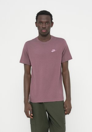 Μπλούζα με κοντά μανίκια και στρογγυλή λαιμόκοψη από βαμβάκι σε μπορντό χρώμα με μικρό ροζ λογότυπο Nike στο στήθος· σε συνδυασμό με πράσινο παντελόνι cargo.