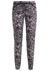 Pantalon slim avec imprimé animal abstrait noir, blanc et gris et bordure noire sur les poches avant, présenté sur fond blanc.