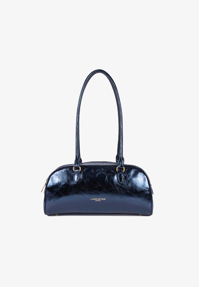 Sac à main en cuir verni marine avec une forme arrondie, deux poignées, des accessoires en métal doré et un logo embossé sur le devant.
