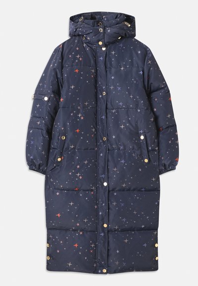 Jūras spēku pildīta jaka ar kapuci, kas rotāta ar zvaigžņu rakstu oranžos un pelēkos toņos. Ietver pogas un divas sānu kabatas.