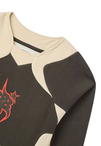 Felpa grigia e beige con collo a giro, caratterizzata da un design grafico astratto rosso, tessuto testurizzato e dettagli di color blocking a contrasto.