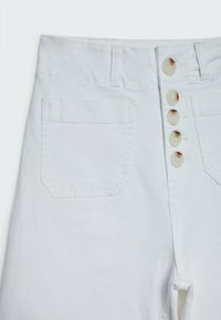 Pantalones de algodón blancos con cintura alta, cierre de cinco botones y un solo bolsillo trasero de forma rectangular con costuras limpias.