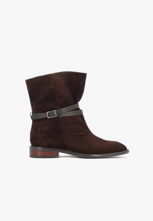 Smeđi antilop čizme do članaka s preklopnim vrhom, kožnim remenom i detaljem kopče, te složenim drvenim potplatom. Glatka tekstura i elegantan oblik.