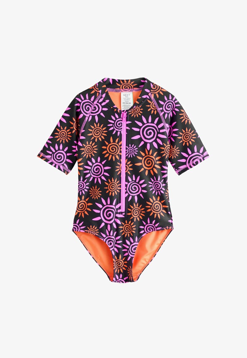 Maillot de bain noir à manches courtes avec des motifs spirales et soleils vibrants en rose et orange, équipé d'une fermeture éclair à l'avant et d'une doublure orange contrastante.