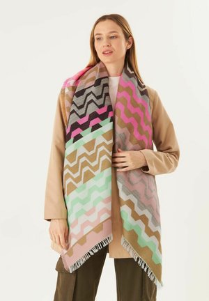 Gewebter Schal mit Zickzackmuster in rosa, grau, mint und beige Tönen, mit fransigen Kanten, die um die Schultern eines Models drapiert sind.