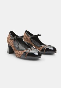 Leopard print Mary Jane heels with black patent leather accents, rounded toe, adjustable strap, and a chunky heel.
