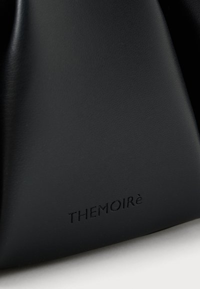 Svart lærveske med en jevn tekstur og subtil glans. Merkenavnet "THEMOIRè" er preget langs bunnen.