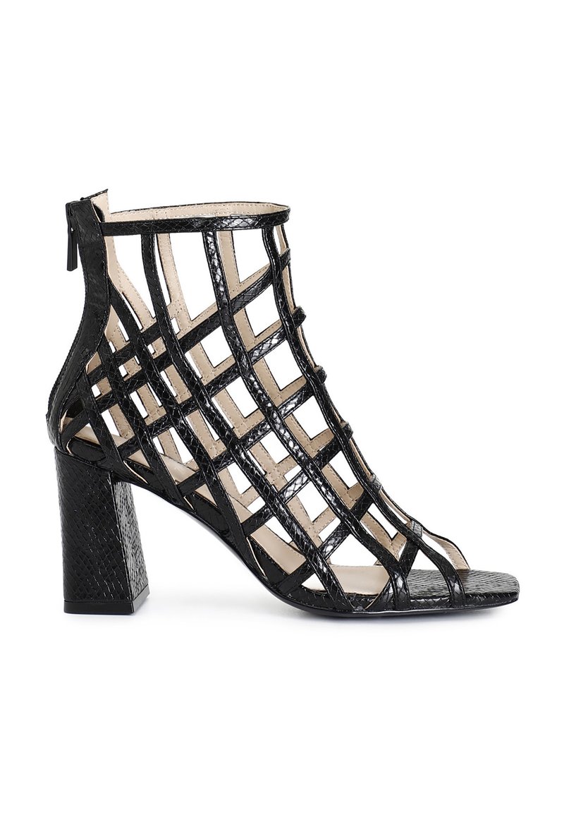 Sandal de tacón negro con un diseño de entramado trenzado, hecho de piel sintética texturizada. Cuenta con un cierre de cremallera en la parte trasera y una punta abierta.