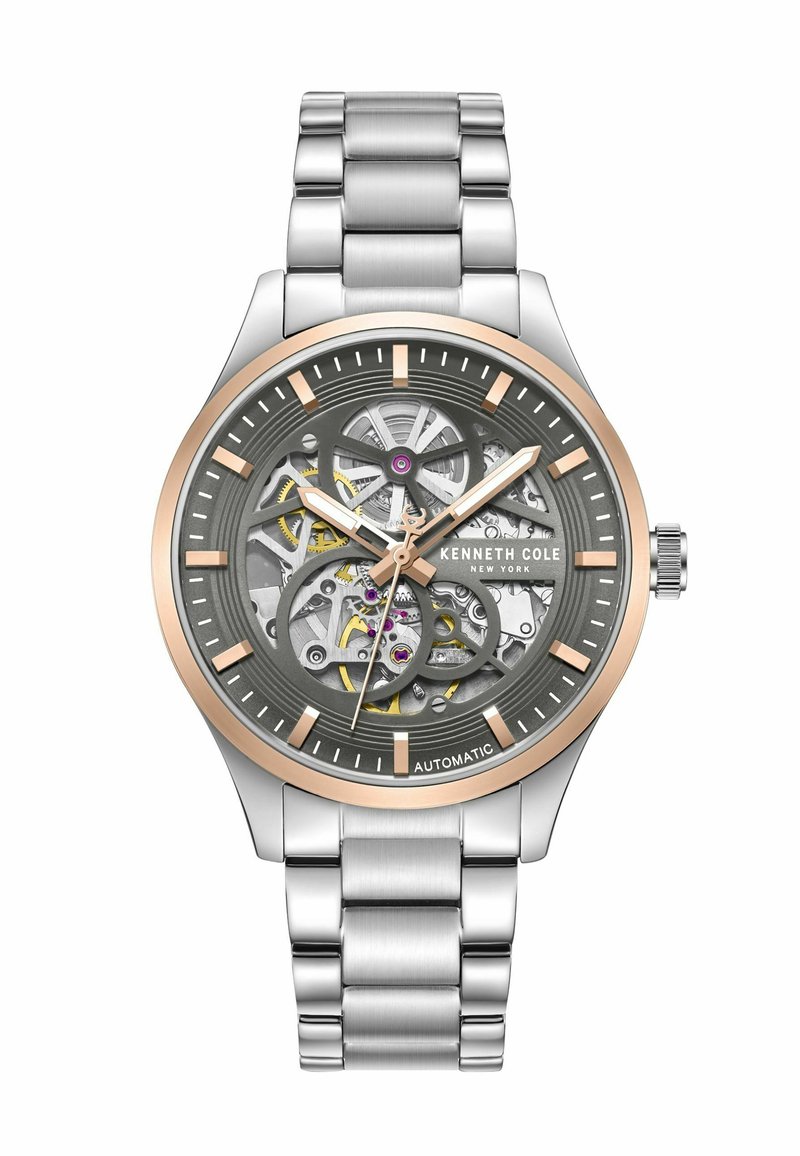 Szkieletowy zegarek automatyczny z srebrną bransoletą ze stali nierdzewnej, szarym cyferblatem z złotymi akcentami oraz odkrytymi detalami mechanizmu.