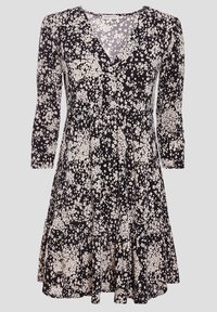 Robe noire avec un col en V et des manches trois-quarts, présentant un motif floral blanc, un tissu texturé et un ourlet à volants.