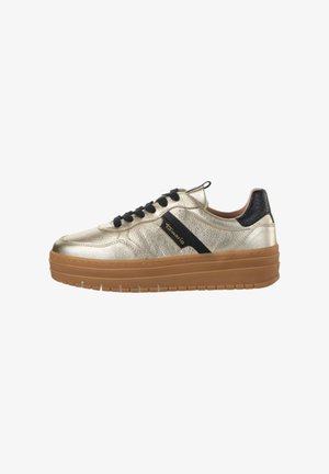 Gold metallic sneaker with black accents, lace-up design, thick rubber sole, textured surface, and branded detailing on the side.