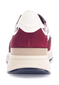 Rode en witte sneaker met een bovenwerk van suede en leer, een gevoerde hielstrip en een beige tussenzool. Beschikt over een gestructureerde zwarte rubberen buitenzool.