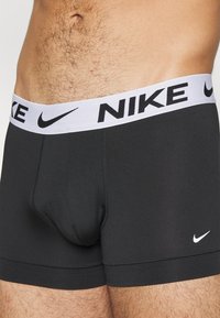 Crne Nike bokserice imaju bijeli elastični pojas s "NIKE" natpisom, mekani su materijal i uski dizajn s oblikovanim džepom.