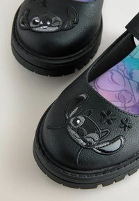 Czarne syntetyczne buty z okrągłym noskiem, ozdobione haftowanym wzorem postaci oraz kolorową, wzorzystą wkładką. Teksturowana podeszwa zapewniająca przyczepność.