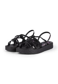 Schwarze Sandalen mit Kreuzriemen-Design, Gummisohle und strukturiertem Fußbett. Die Riemen weisen sowohl glänzende als auch matte Oberflächen auf.