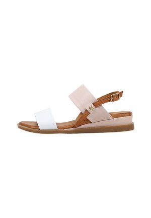 Sandalia plana con tira blanca en los dedos, tira beige en el tobillo con hebilla, detalles en piel marrón y suela acolchada color beige, vista lateral sobre fondo blanco.