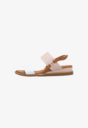 Sandalia plana con tira blanca en los dedos, tira beige en el tobillo con hebilla, detalles en piel marrón y suela acolchada color beige, vista lateral sobre fondo blanco.