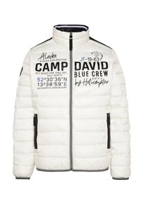 Giacca puffer bianca con motivo trapuntato orizzontale, tasche con zip, colletto alto e grafiche stampate in nero e blu sul davanti.